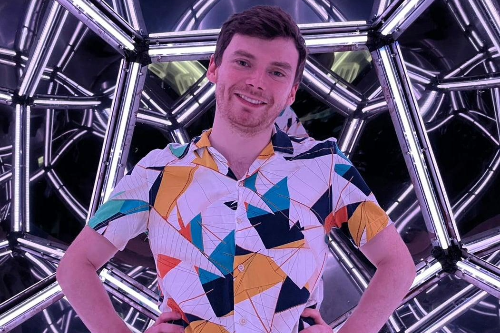 University of Bristol student Franco Labia smiles in front of a light display.